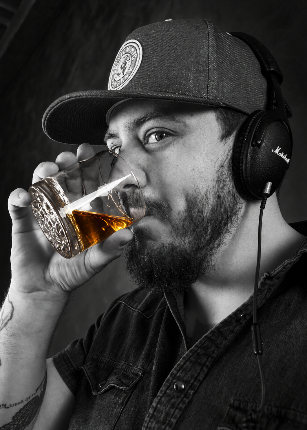 Feral Business drinking whiskey while wearing studio headphones